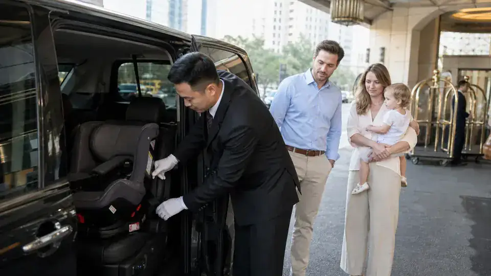 Parent and chauffeur checking a child safety seat inside a private MPV in China