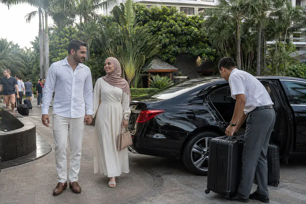 Middle Eastern honeymoon couple arriving at a Sanya resort by premium sedan