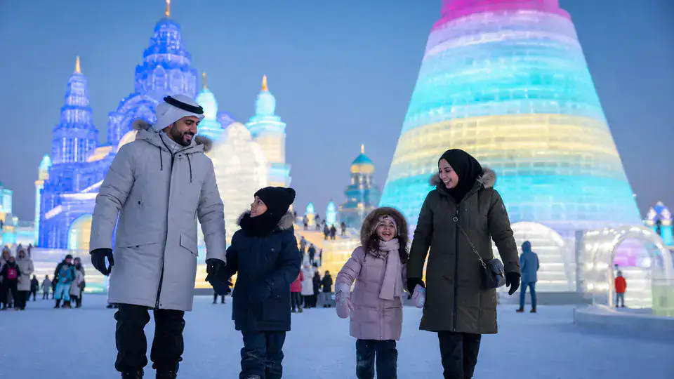 Gulf family visiting Harbin Ice and Snow World in heavy winter clothing