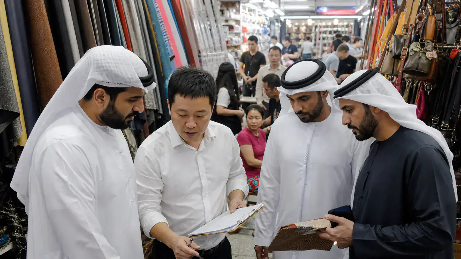 UAE buyers working with a sourcing guide inside a Guangzhou wholesale market