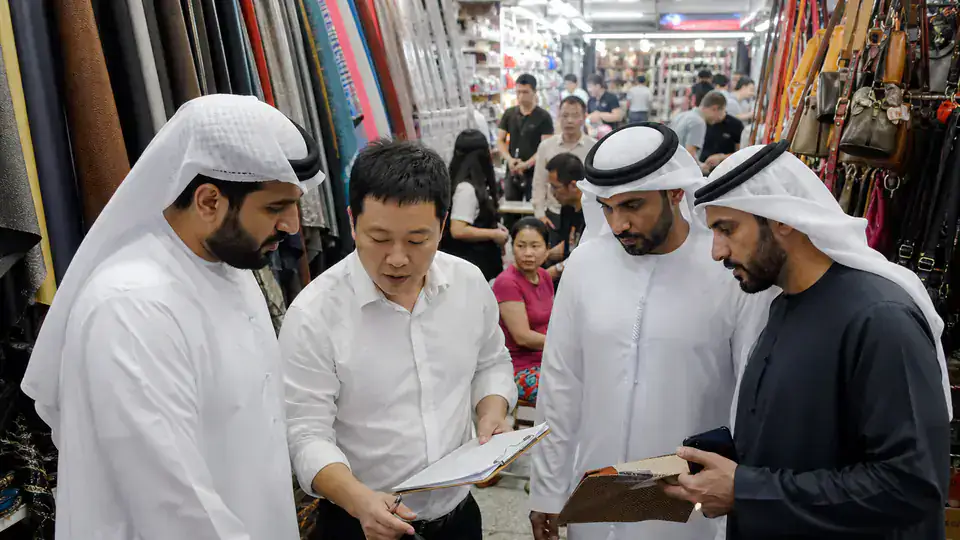 UAE buyers working with a sourcing guide inside a Guangzhou wholesale market