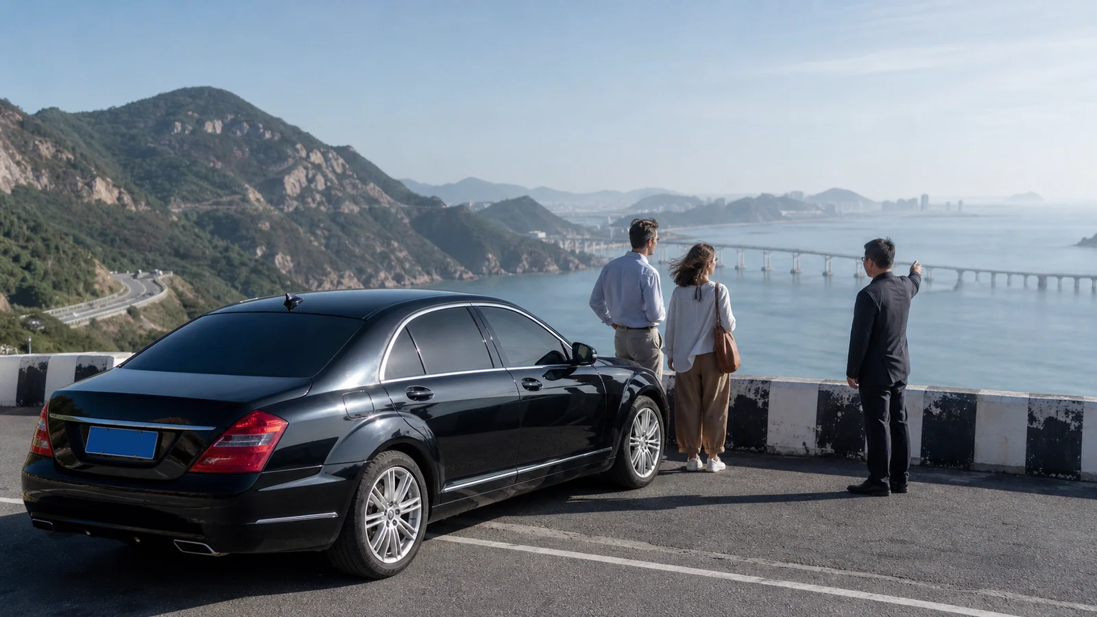 International travelers viewing the Dalian coast beside a private chauffeur car on Binhai Road