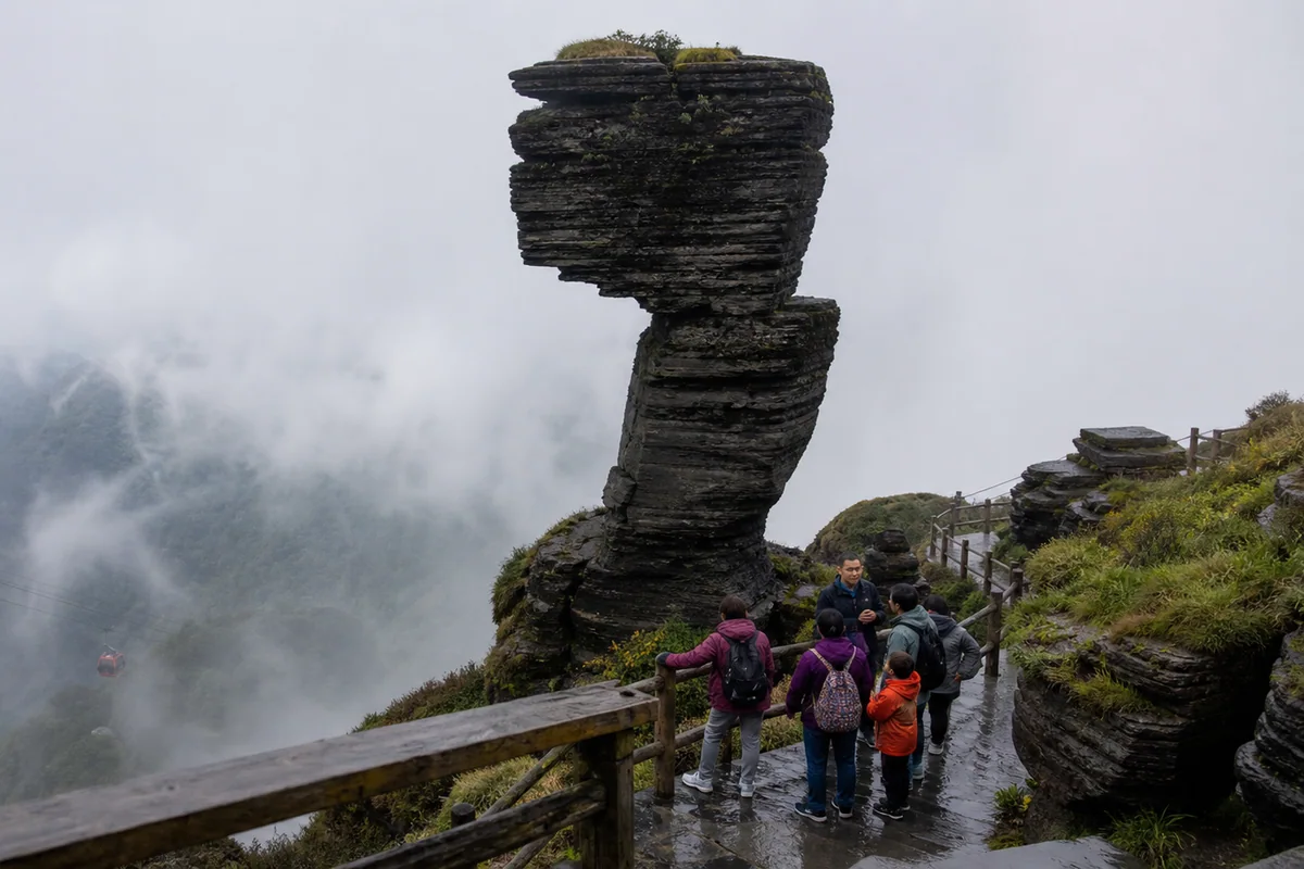 Mushroom Stone and a cable car emerging through mountain mist at Fanjingshan