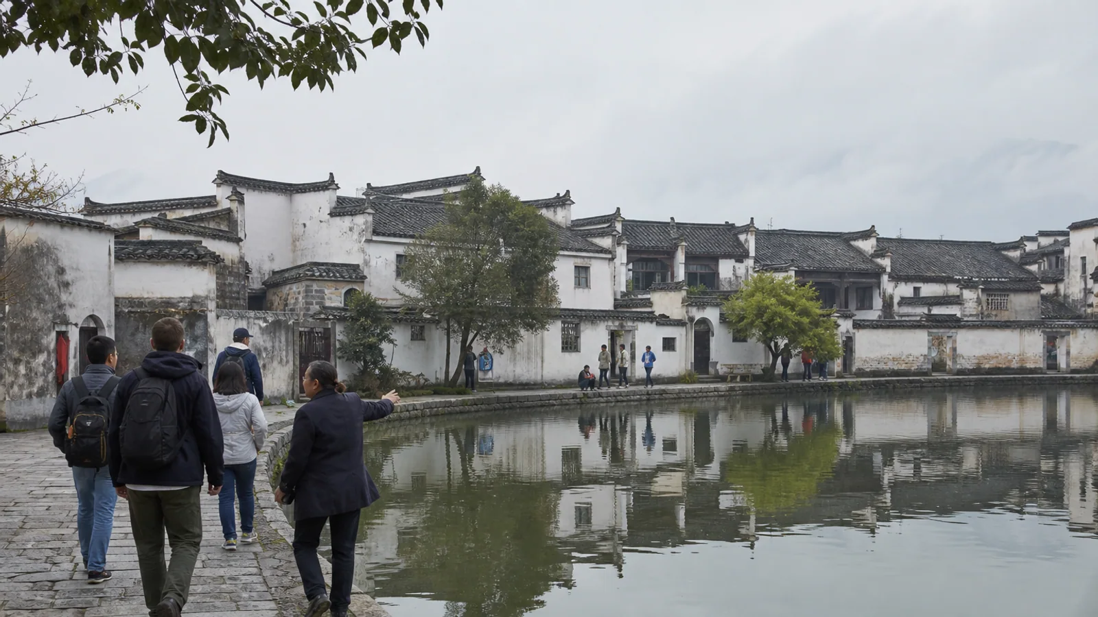 International travelers and guide beside Moon Pond in Hongcun village