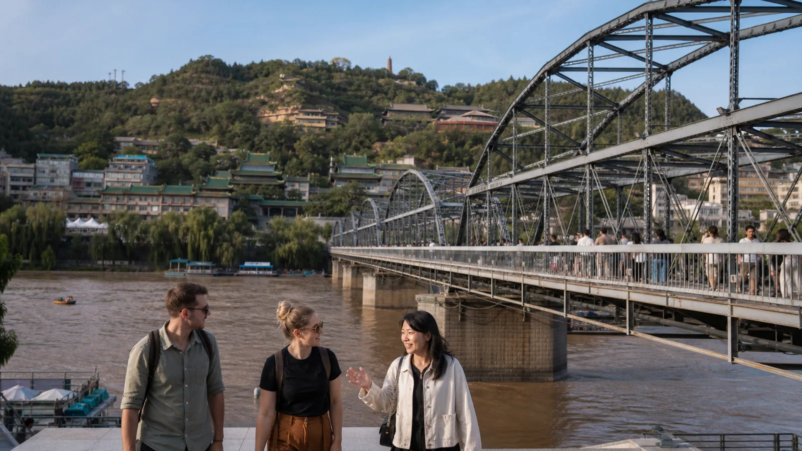 International travelers and local guide beside Zhongshan Bridge on the Yellow River in Lanzhou