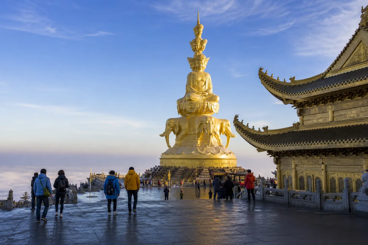 Visitors approaching the golden Samantabhadra statue on Mount Emei above the clouds