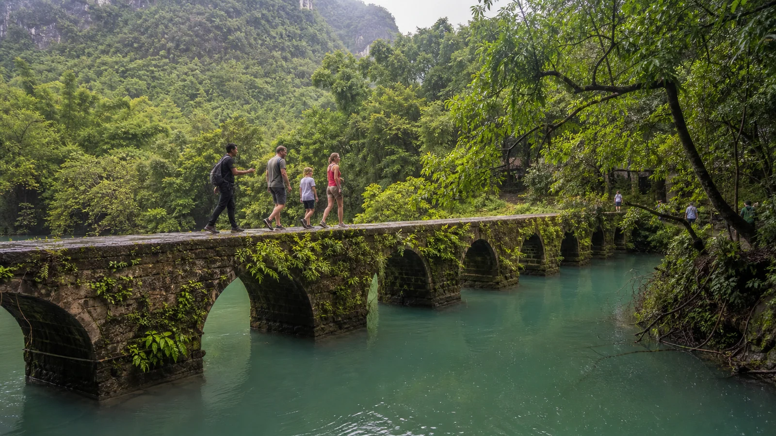 Family crossing the old seven arch bridge at Xiaoqikong in Libo