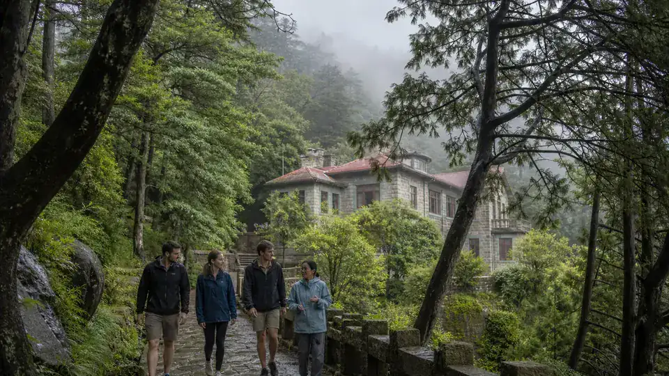 International travelers walking through mist near historic villas on Mount Lushan