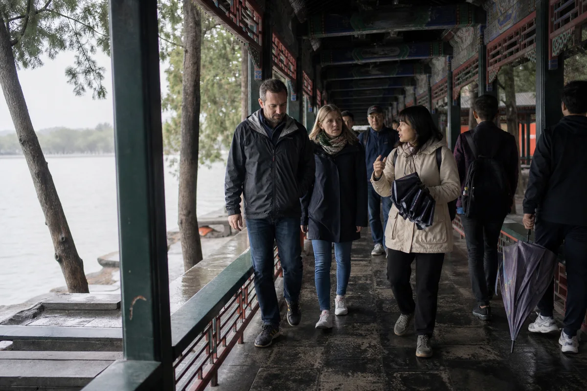 Travelers walking through the painted Long Corridor at the Summer Palace after rain