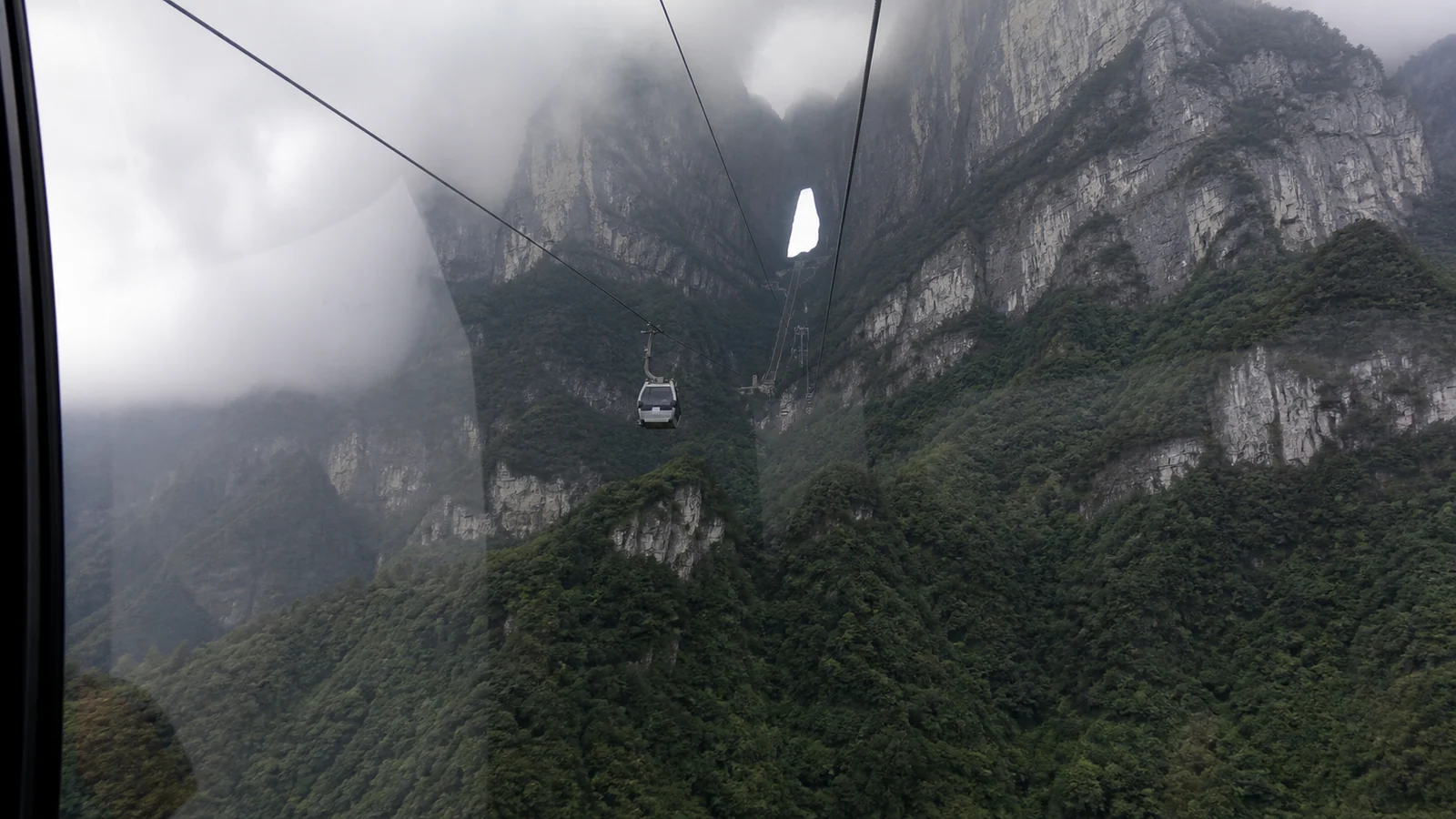 Cable car approaching Tianmen Mountain through cloud