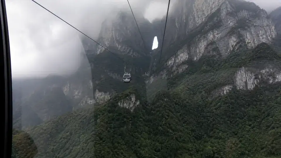 Cable car approaching Tianmen Mountain through cloud