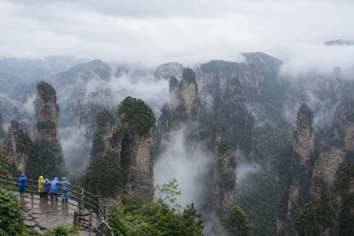 Sandstone pillars and visitors in raincoats at Zhangjiajie National Forest Park
