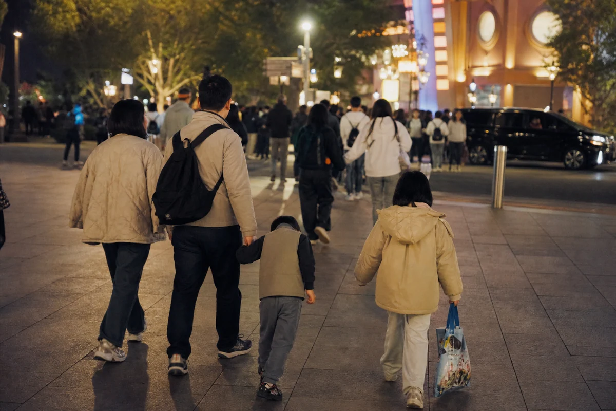 A tired family leaving a Beijing theme park toward an evening pickup