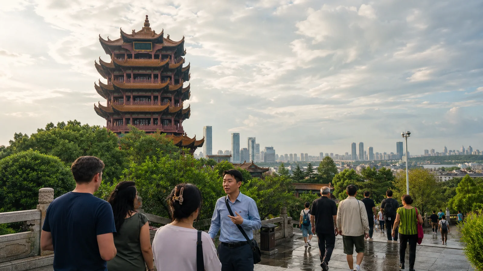 Travelers visiting Yellow Crane Tower with the modern Wuhan skyline beyond