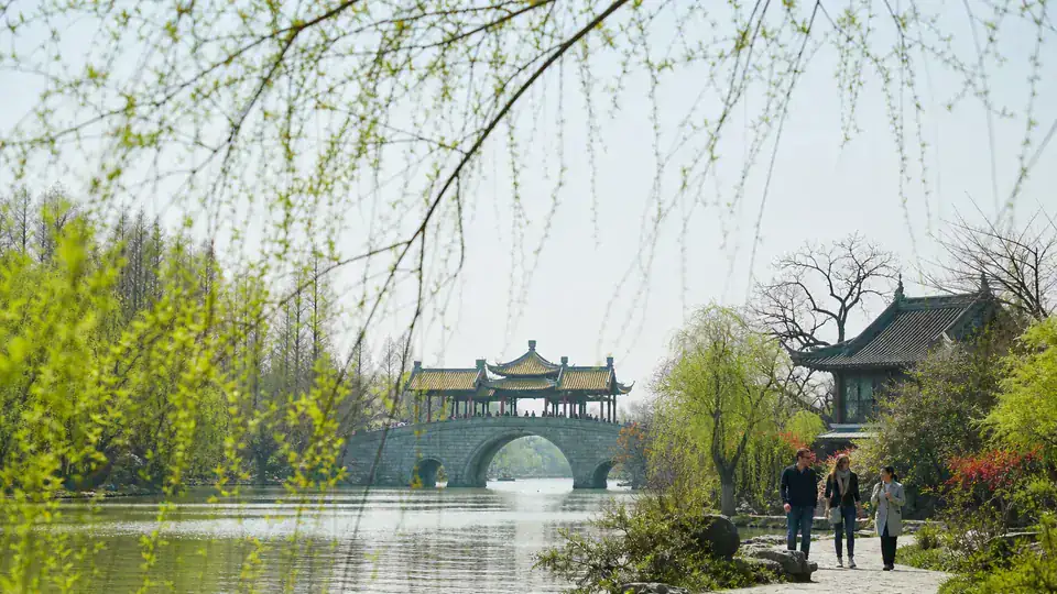 International travelers exploring Slender West Lake in Yangzhou with a local guide