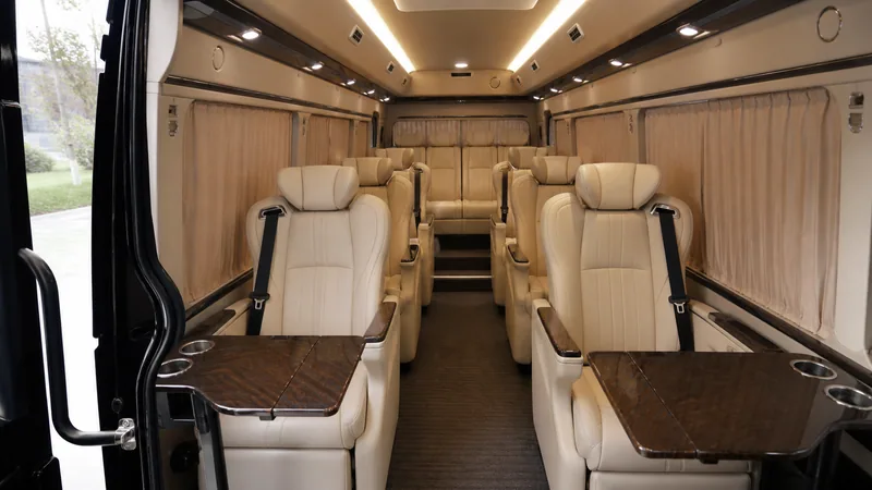 Cream leather VIP group cabin with a wide aisle, reclining seats and private tables