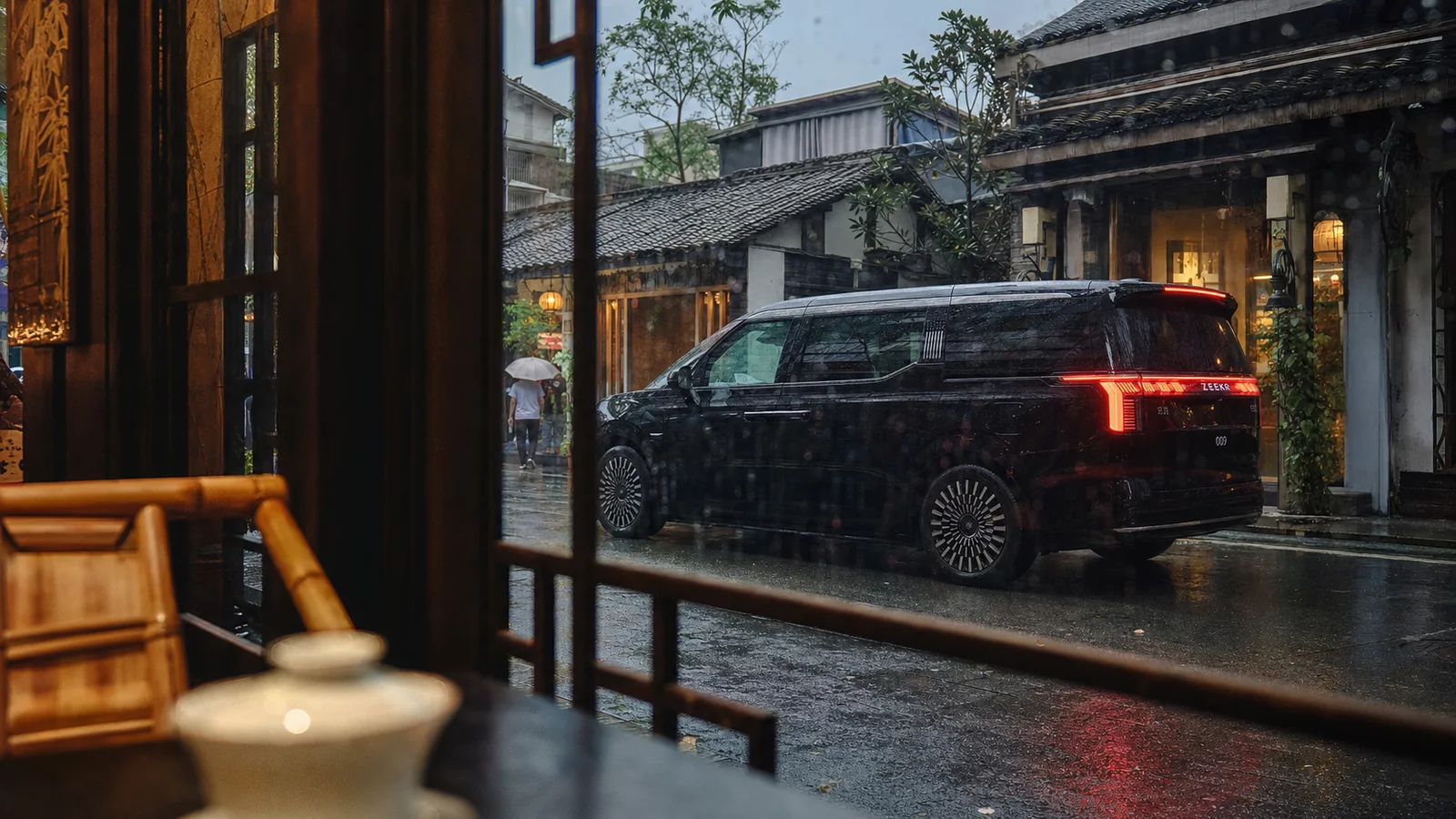 Black ZEEKR 009 seen through a rainy Chengdu teahouse window