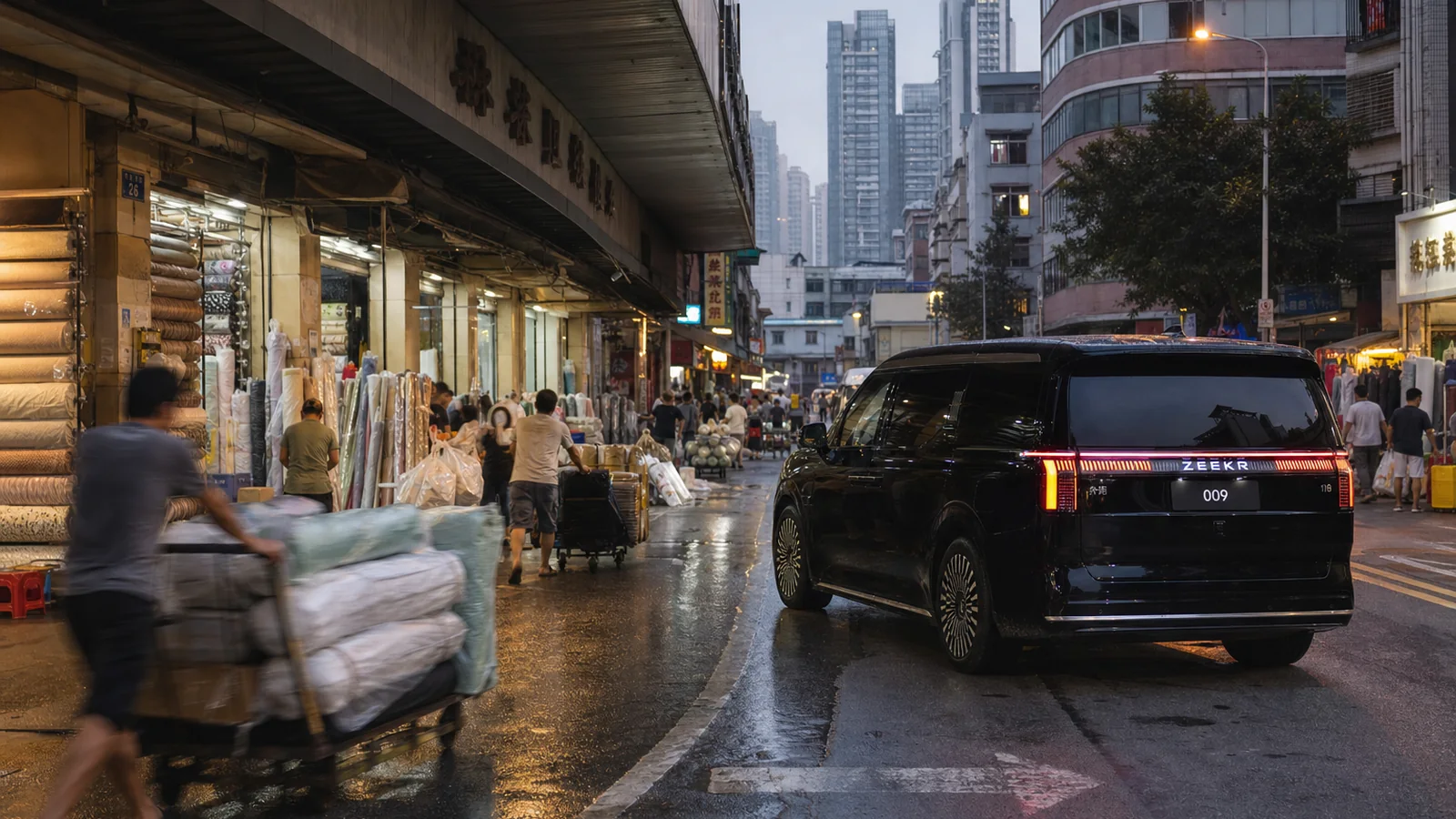 Black ZEEKR 009 waiting beside a busy Guangzhou wholesale market