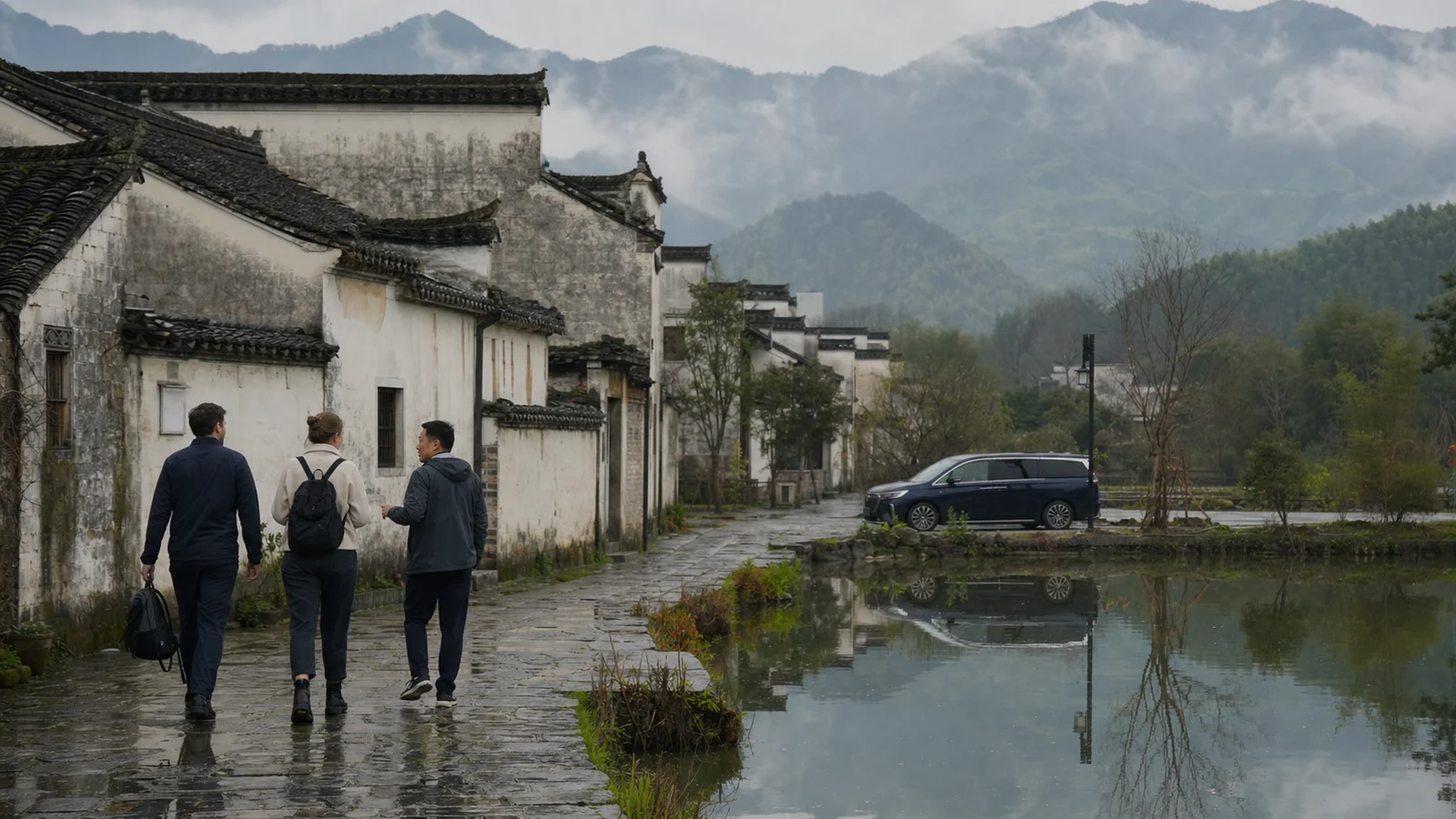 Travelers walking through a traditional Huizhou village near Huangshan on a rainy morning