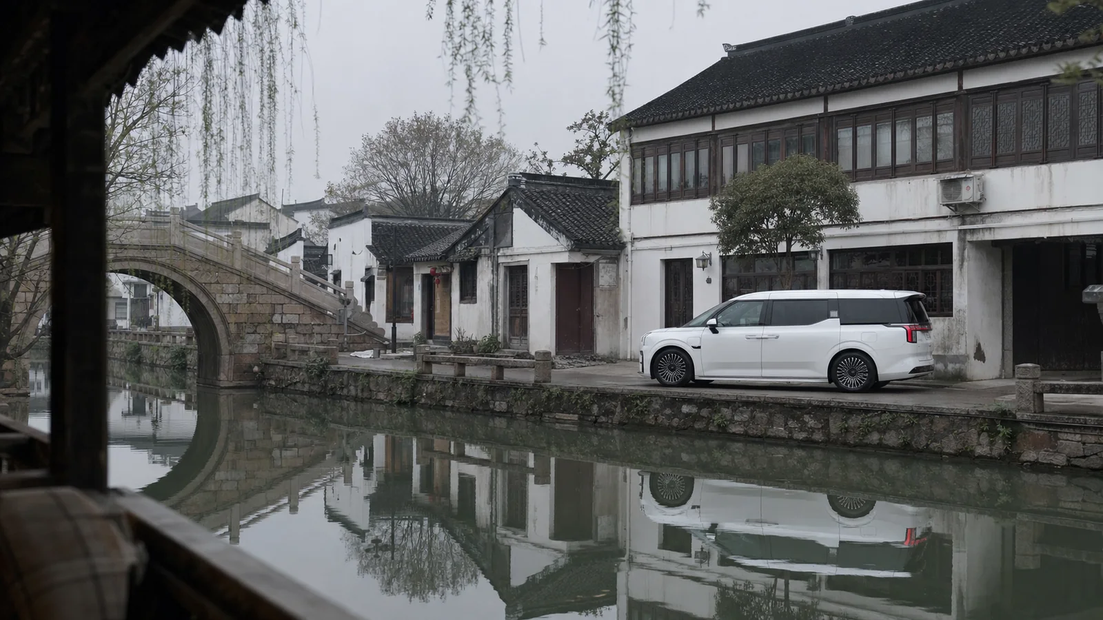 White ZEEKR 009 beside a quiet canal and stone bridge in Suzhou