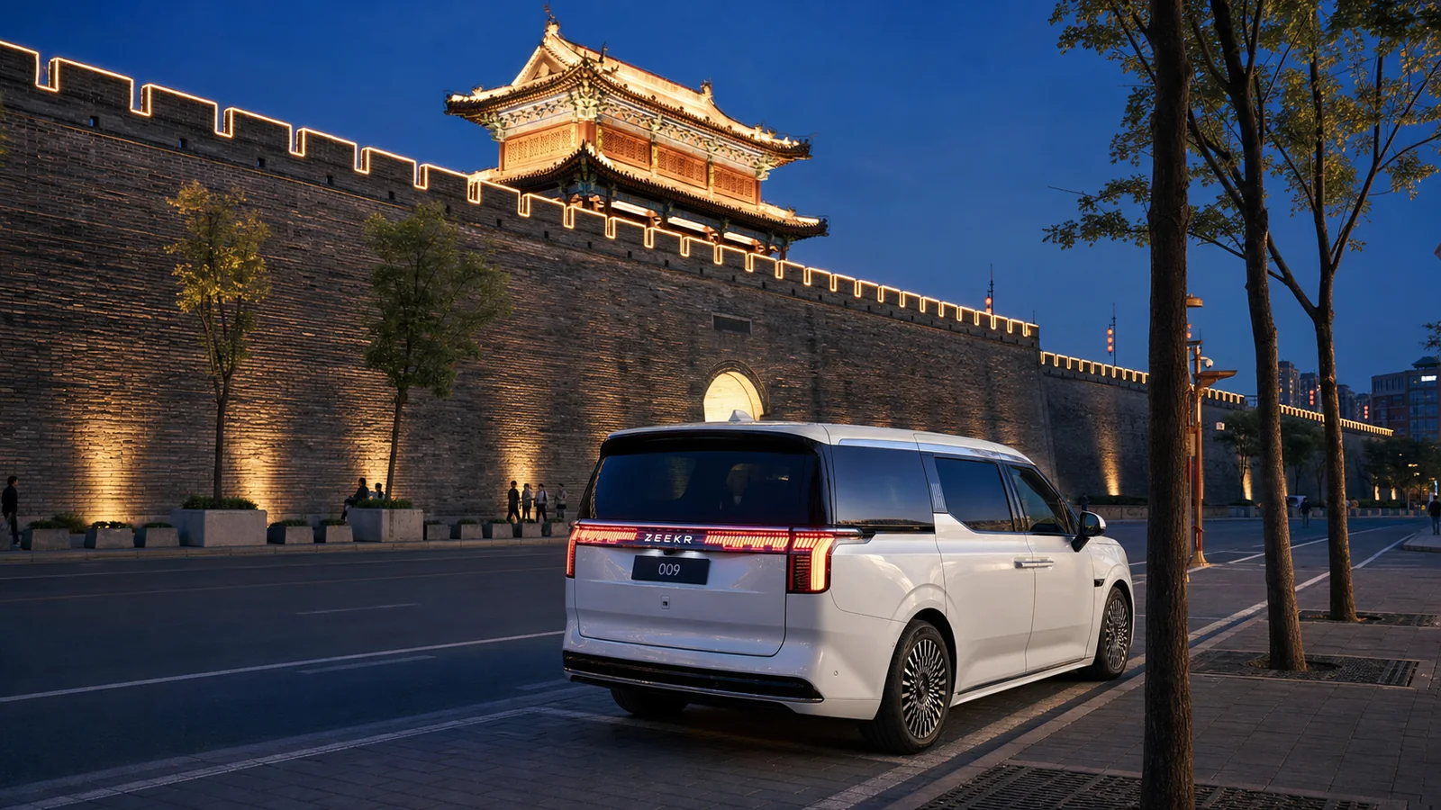 White ZEEKR 009 beside Xi'an City Wall at blue hour